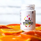 Flacon Multivitamines 21 nutriments Nutripure posé sur des tranches d'agrumes frais – complément énergie et immunité